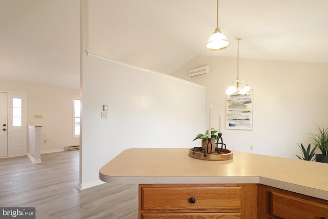 kitchen featuring an inviting chandelier, a baseboard heating unit, a wall unit AC, decorative light fixtures, and light wood-type flooring