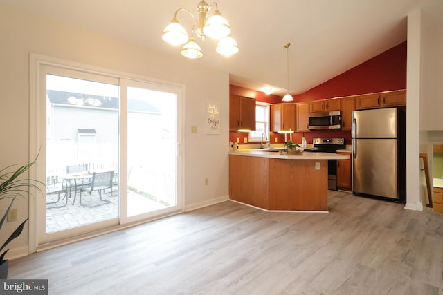 kitchen with kitchen peninsula, a healthy amount of sunlight, pendant lighting, and stainless steel appliances