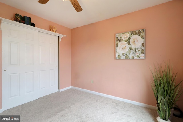 unfurnished bedroom featuring ceiling fan, light carpet, and a closet