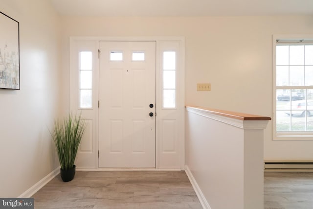 foyer with light wood-type flooring and baseboard heating