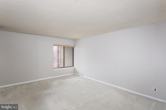 carpeted empty room with a textured ceiling