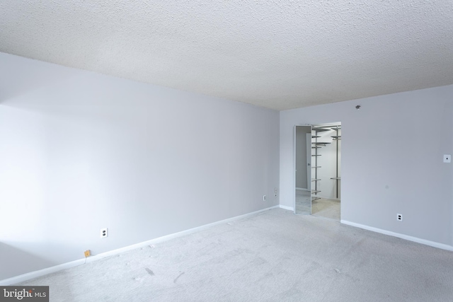 carpeted spare room featuring a textured ceiling