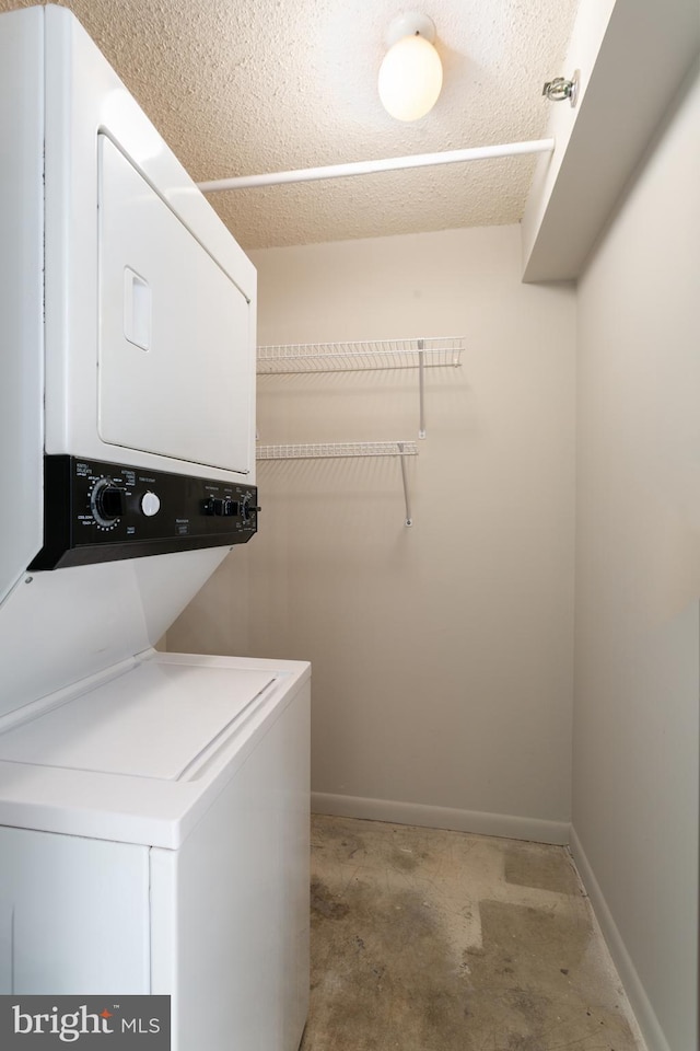 washroom featuring stacked washing maching and dryer and a textured ceiling