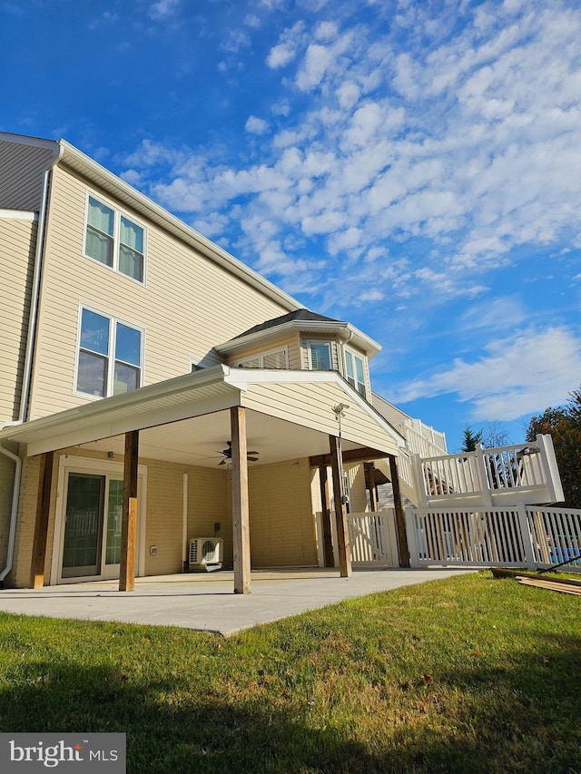 back of house with ceiling fan, a patio, and a lawn