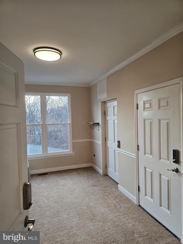 unfurnished room with crown molding and light colored carpet