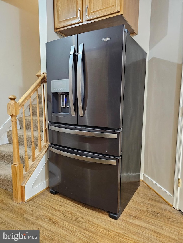 kitchen featuring stainless steel fridge, light brown cabinetry, and light hardwood / wood-style flooring