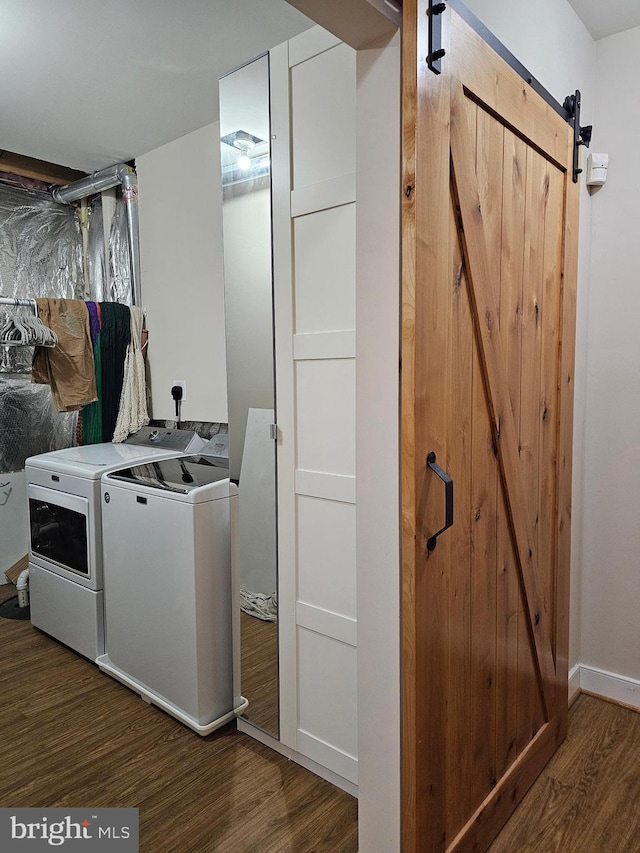 laundry area featuring washer and dryer, dark hardwood / wood-style floors, and a barn door