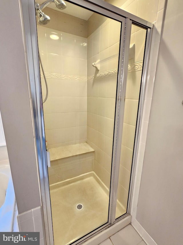 bathroom with tile patterned flooring and a shower with shower door