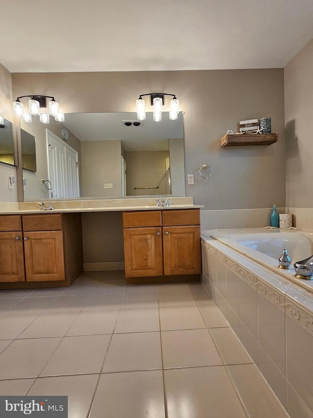 bathroom featuring vanity, tiled bath, and tile patterned floors