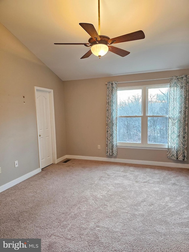 carpeted empty room with vaulted ceiling and ceiling fan