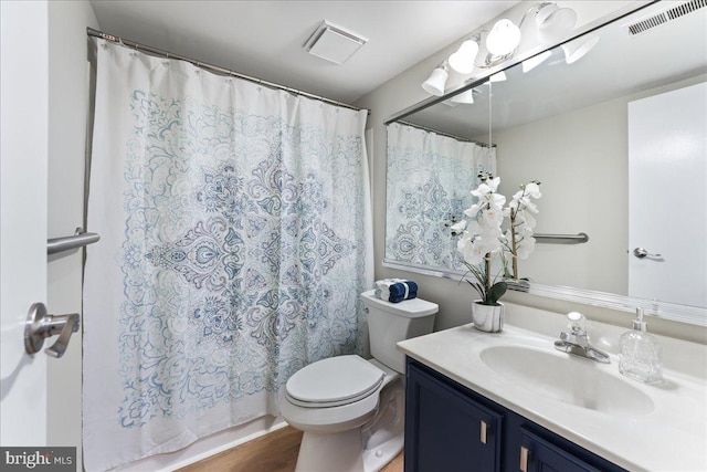 bathroom with toilet, vanity, and hardwood / wood-style flooring