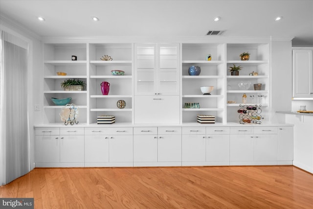 bar featuring white cabinets and light hardwood / wood-style floors