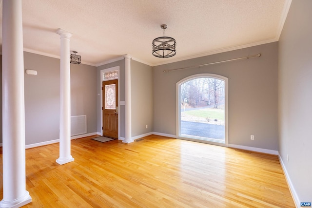 entryway featuring wood-type flooring, a textured ceiling, an inviting chandelier, and crown molding