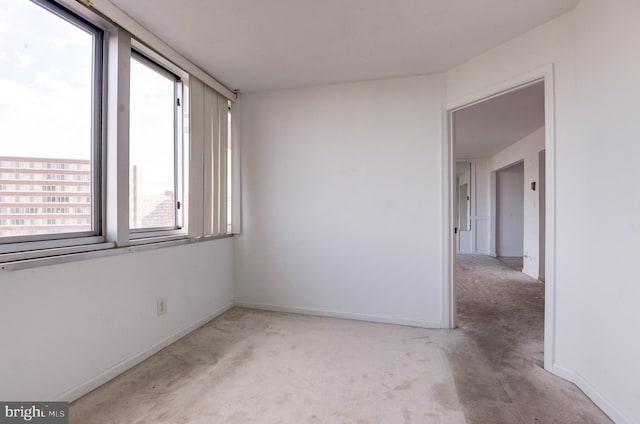 empty room with light colored carpet and a healthy amount of sunlight