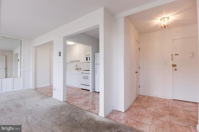 carpeted foyer featuring sink