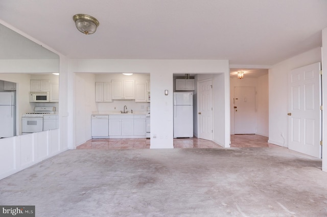 unfurnished living room with sink and light colored carpet