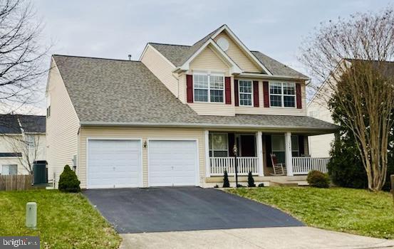 view of front facade with central AC, a garage, a porch, and a front yard