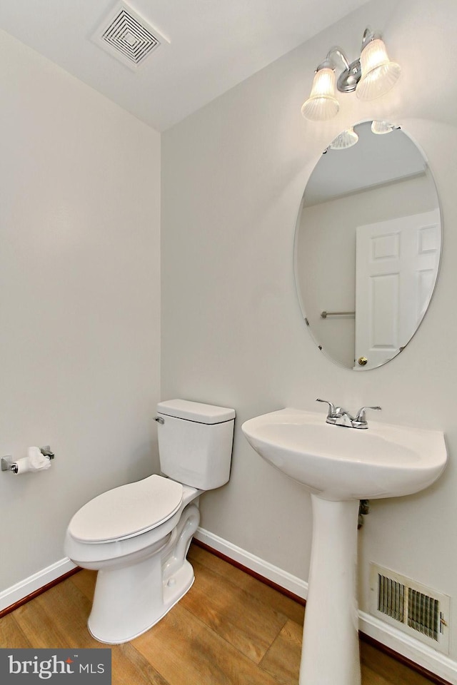 bathroom featuring hardwood / wood-style flooring and toilet