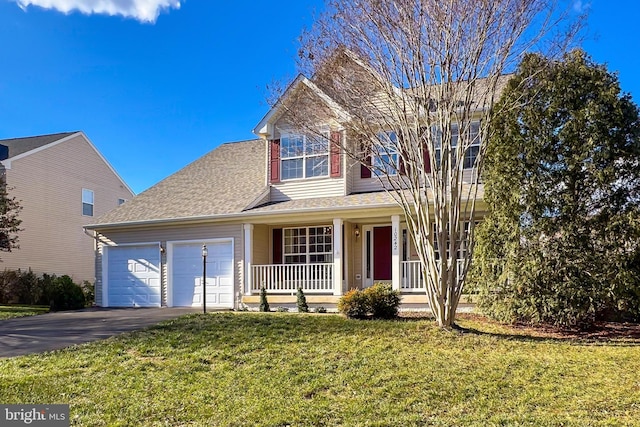 view of front of home featuring covered porch, a garage, and a front yard