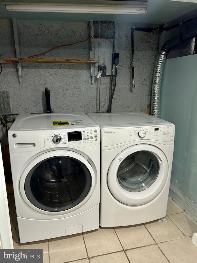 laundry room with light tile patterned floors and washing machine and dryer