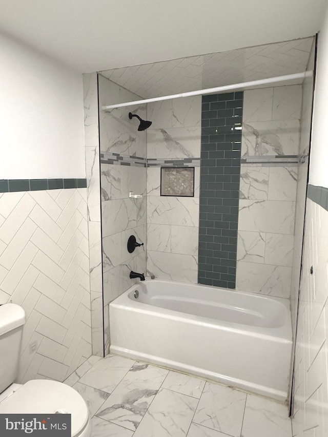 bathroom with toilet and tiled shower / bath