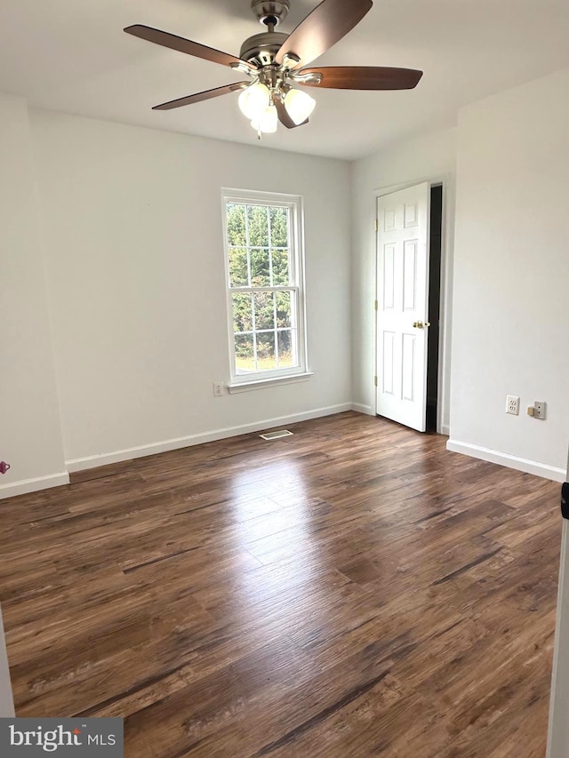 spare room featuring dark hardwood / wood-style floors and ceiling fan