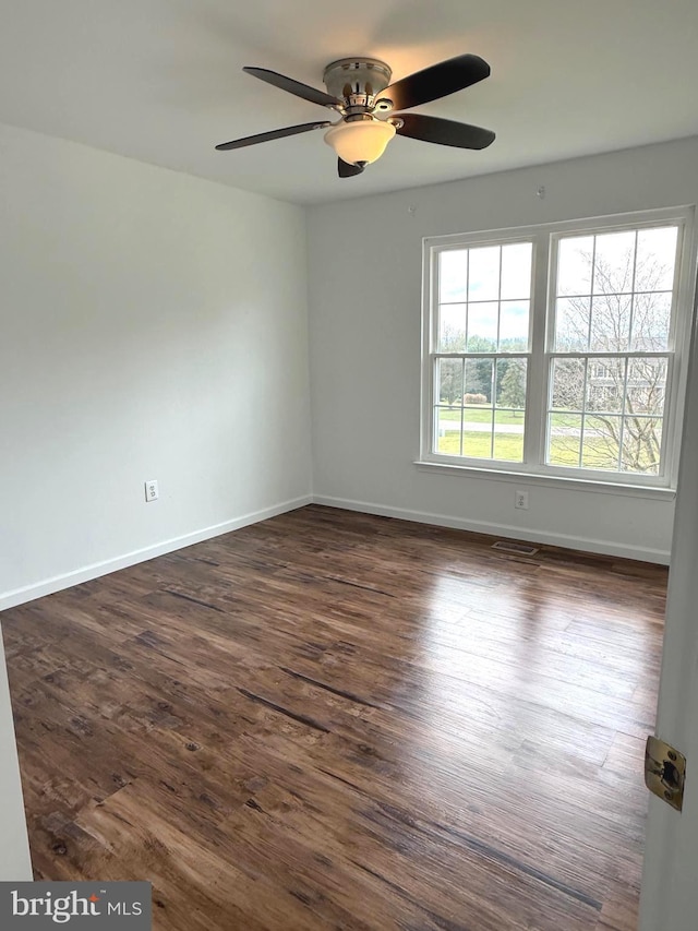 spare room with ceiling fan and dark wood-type flooring