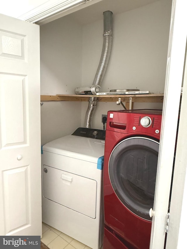 clothes washing area featuring independent washer and dryer and light tile patterned flooring