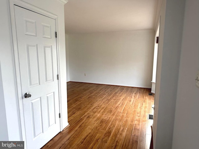 unfurnished room featuring hardwood / wood-style floors and ornamental molding