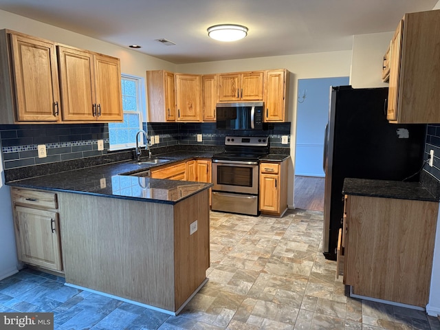 kitchen with refrigerator, sink, stainless steel electric range oven, tasteful backsplash, and kitchen peninsula