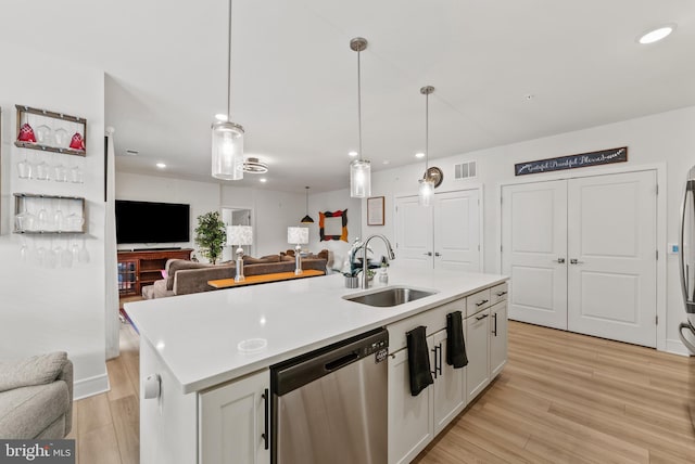 kitchen featuring white cabinets, dishwasher, sink, and a kitchen island with sink