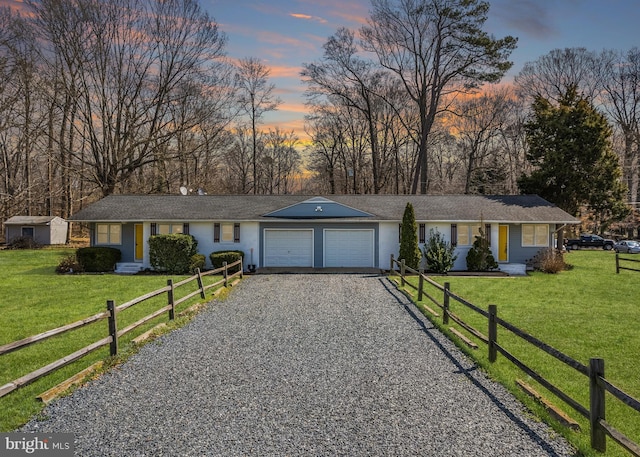 ranch-style home featuring a garage and a yard