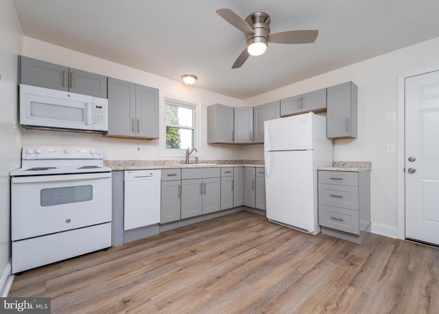 kitchen featuring white appliances, sink, ceiling fan, gray cabinets, and light wood-type flooring