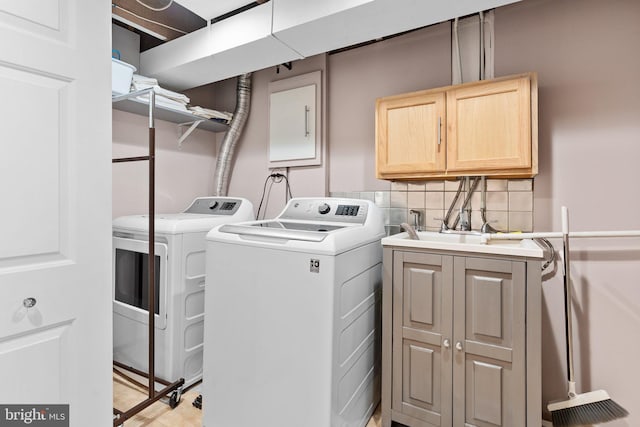 laundry room featuring cabinets, sink, and washing machine and dryer