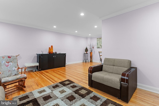 living area featuring hardwood / wood-style floors and ornamental molding