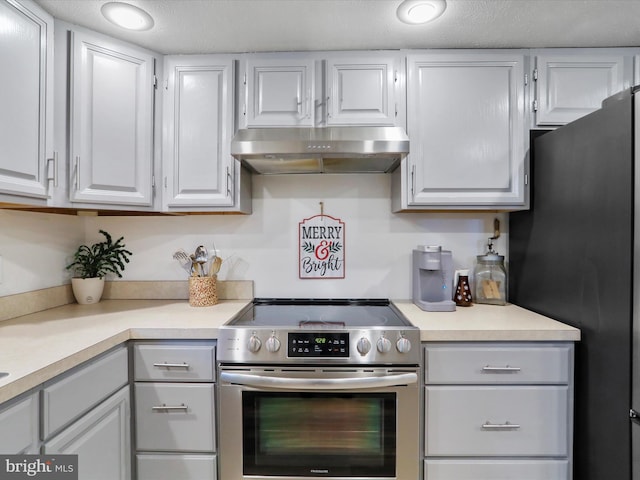 kitchen with a textured ceiling, stainless steel appliances, and white cabinetry