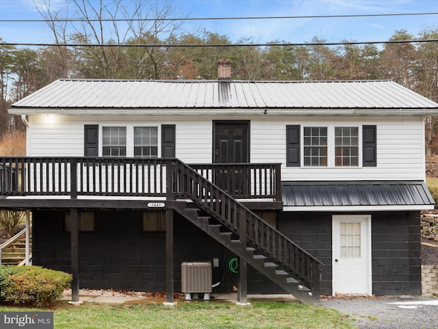 rear view of property featuring a deck and central AC