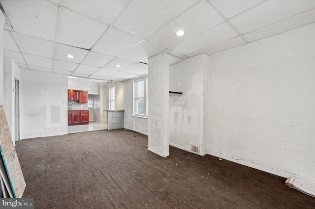 unfurnished living room featuring a paneled ceiling