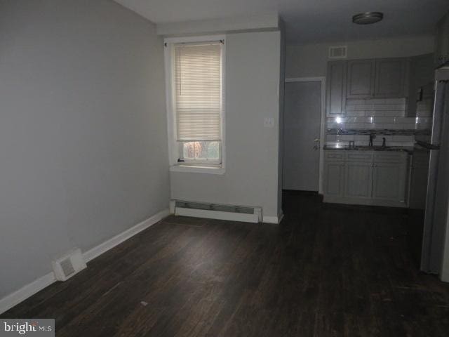 interior space with a baseboard radiator, dark hardwood / wood-style floors, and sink