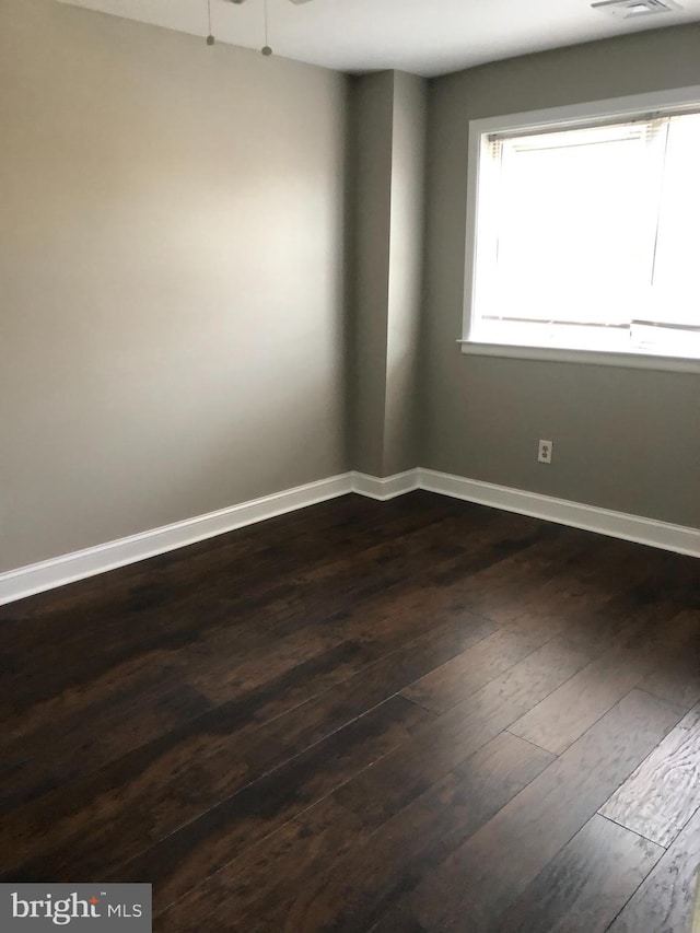 empty room with dark wood-type flooring