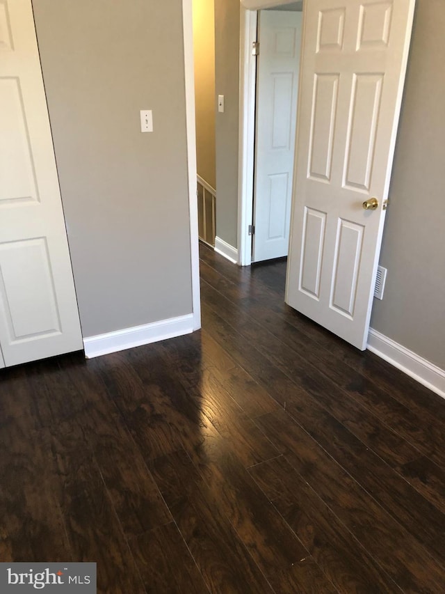 empty room with dark wood-type flooring