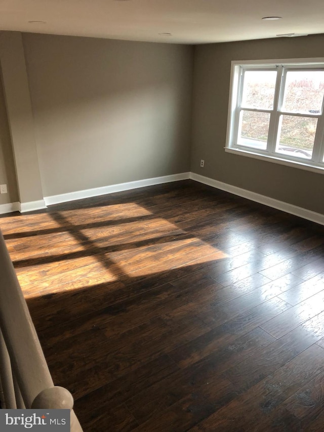 unfurnished room with dark hardwood / wood-style flooring