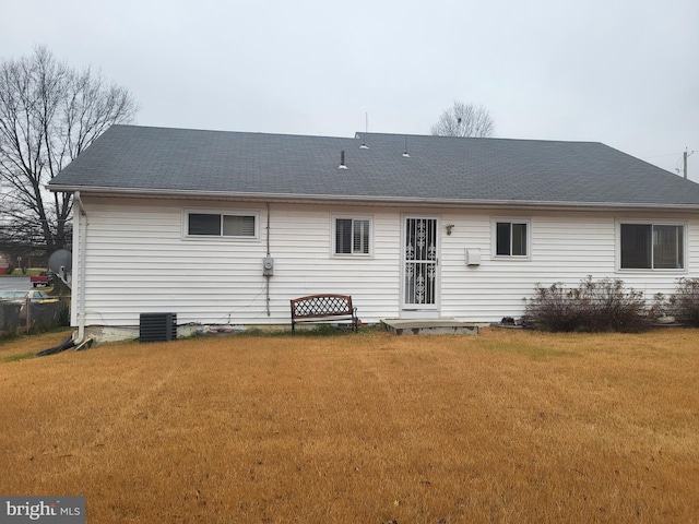 back of house with a lawn and central air condition unit