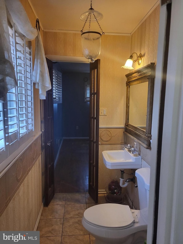 bathroom featuring toilet, sink, and tile patterned flooring