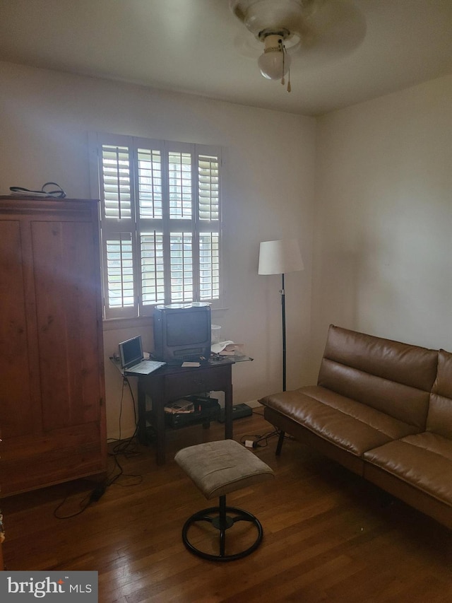 living area with hardwood / wood-style floors and ceiling fan