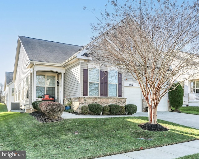 view of front of home with central air condition unit, a front lawn, and a garage