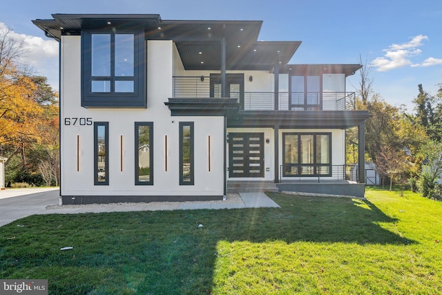 back of property featuring a lawn and a balcony