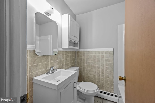 bathroom featuring a baseboard radiator, tile walls, toilet, and vanity