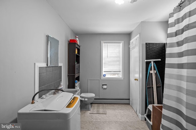 bathroom featuring a baseboard radiator, washer and clothes dryer, and toilet