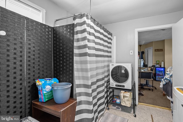 bathroom featuring tile patterned floors, walk in shower, and washer / clothes dryer